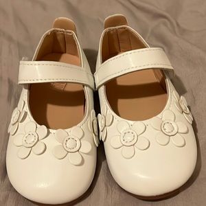Cream colored baby Maryjane’s with flowers on front. New without tag. Size 23